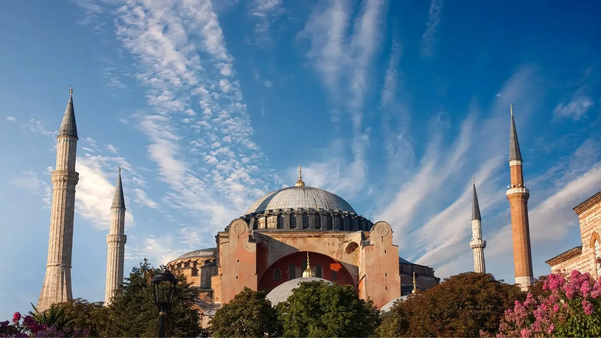 Exterior view of Hagia Sophia beneath a dramatic blue sky in Istanbul.
