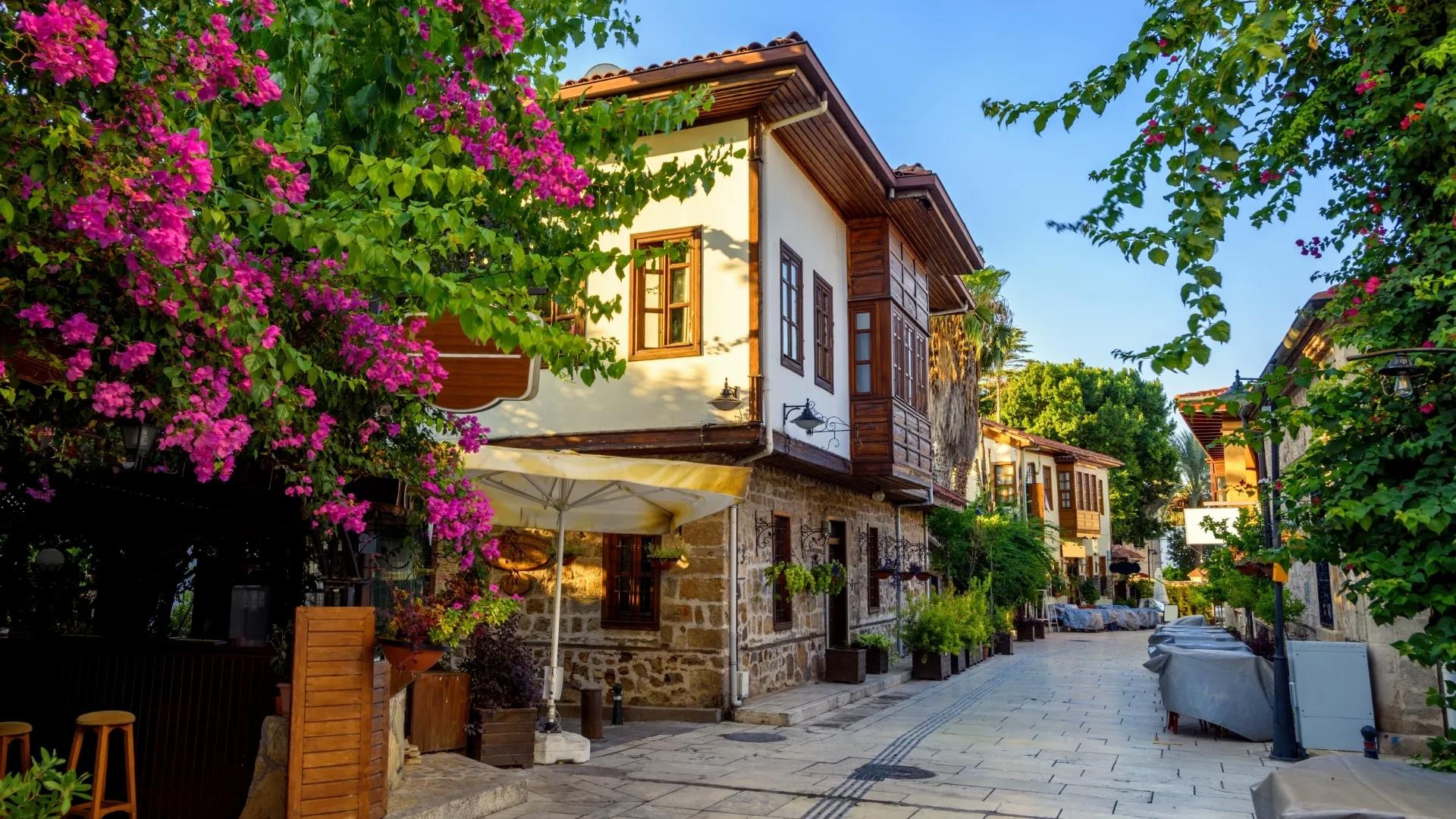 Traditional Ottoman houses, stone streets, and colorful bougainvillea in Antalya Old Town, also known as Kaleici.