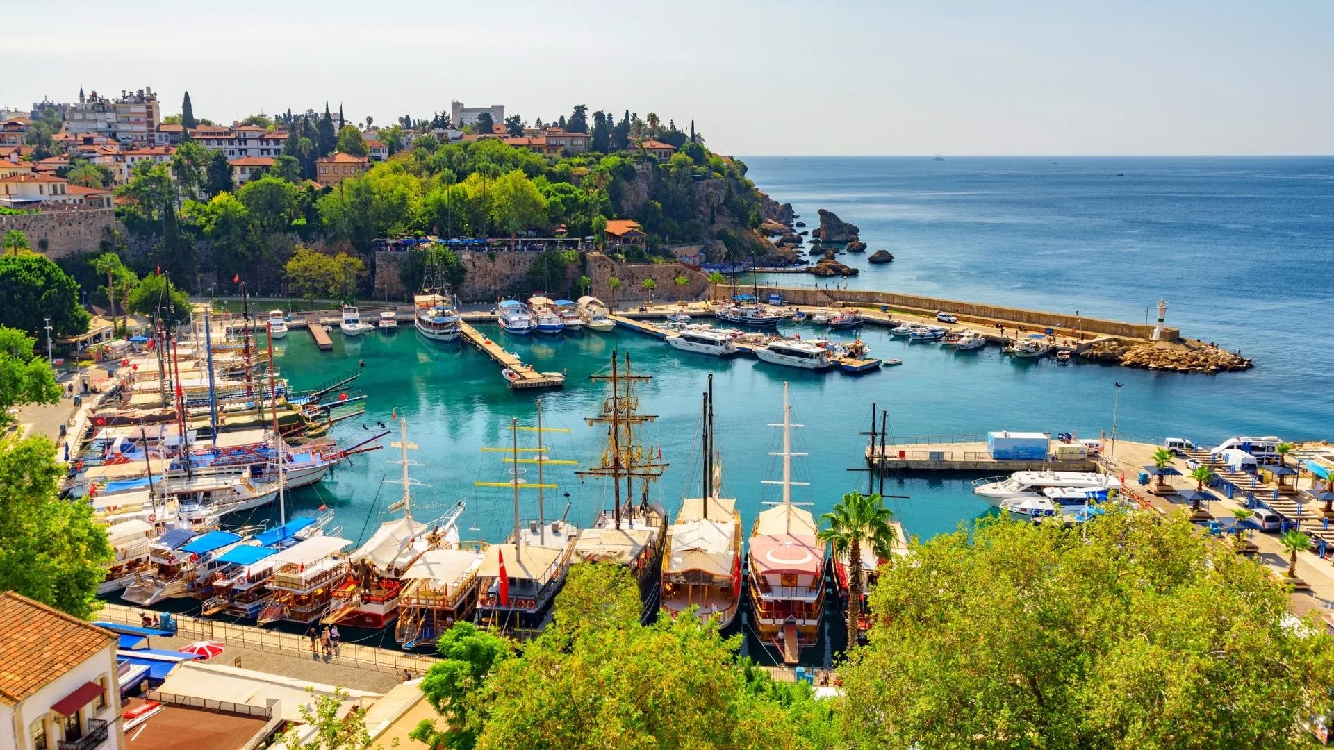 Antalya Old Harbor from above, featuring traditional tour boats, turquoise waters, and the historic Kaleici coastline.